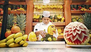 A chef prepares a dog from fruit aboard the luxury cruise ship AIDAdiva.