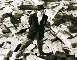 Orson Welles astride stacks of newspaper in Citizen Kane