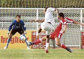 Sporting Clube de Goas Ernest Jeremiah takes a shot at the goal as JCT defender Gurwinder Singh attempts to stop him in the 11th National Football League at Ludhianas Guru Nanak Stadium