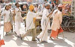 A lame person helps four visually challenged ones as they beg for livelihood in Ludhiana.