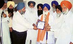 Prof Kirpal Singh Badungar receives a memento from office-bearers of the Gurdwara Singh Sabha at Ahmedgarh