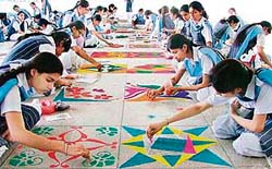 Students of Guru Nanak Public School making colourful Rangoli patterns during a competition.