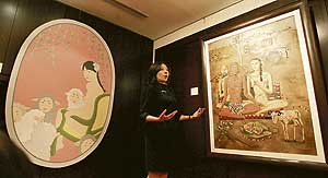 A Christies art expert explains two portraits in Hong Kong on Wednesday. A painting by Shin Young-Mi (on the left) titled, Self Portrait in Jaisalmer, is listed at an estimated price between HK$35,000 and HK$55,000 A selection of contemporary Chinese, Korean, Japanese, Indian and Pakistani art will be put up for auction on Friday.