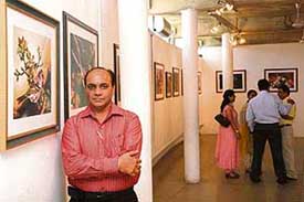 Artist Satish Verma with one of his works on display at Government Museum and Art Gallery, Sector 10, in Chandigarh on Wednesday. 
