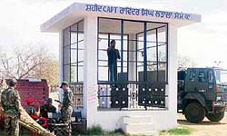 A group of Army men rests in the shade of the cabin housing the statue of Captain Ravinder Singh at Latala village near Ahmedgarh.