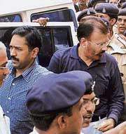 IPS officers deputy inspector-general of police (border range) D.G. Vanzara (right) and superintendent of police (intelligence) Rajkumar Pandian (left) are brought by the police to appear in a court in Ahmedabad on Wednesday. They were arrested in connection with a fake encounter.