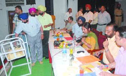 Contractors, their representatives and excise & taxation officers during the allotment process of liquor vends of Jalandhar district at Red Cross Bhavan on Thursday. 