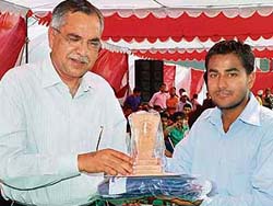The chairman, Hukam Chand Bansal, honours university topper Amandeep at a function at RIMT-IET, Mandi Gobindgarh.