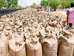 Bags of wheat block a road leading to the grain market in Abohar.