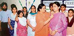 The principal of GGSPS, Ludhiana, pins badges on the new members of the 2007- 08 session at the investiture ceremony held in the school