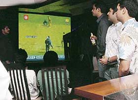 Cricket fans watch the World Cup final match on a big screen in a restaurant in Chandigarh