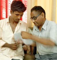 Visually impaired Ravinder Kumar(R) asks a friend to read for him the notice regarding announcement fees