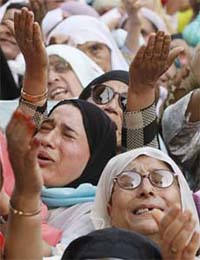 Kashmiri women cry at the shrine of Shiekh Abdul Qadir Jeelani, a Sufi saint, on his death anniversary in Srinagar
