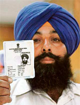 Harjinder Singh shows his photo identity card issued by the Election Commission. Harjinders name is among the deceased in revenue department records.