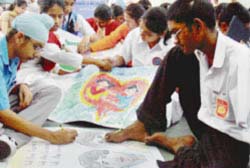 Sunil (right), makes painting through his toes and his friend helps him out at a special interaction session held at Bhartiya Vidya Bhawan, Sector 26
