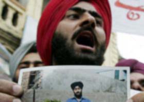 A relative of Parmeet Singh holds his picture during a protest demonstration organised in Srinagar