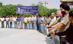 members of the Chandigarh Punjab Union of Journalists (CPUJ) form a human chain at the Sector 17 Plaza on May Day.