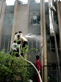 Hindustan Times employees help firemen douse the flames after the newspaper building caught fire in the Capital on Tuesday.