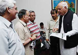 National Conference leader Farooq Abdullah distributes copies of a newspaper that he inaugurated at Jammu.