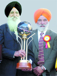 Ontario Sikh Gurdwara Council chairman Harbans Singh honours Raghbir Singh Bains, in Ontario on Sunday.