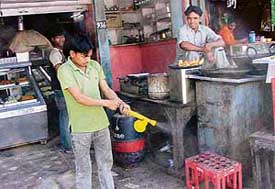 An employee at a shop sprays medicine to get rid of flies in Barwala near Panchkula on Wednesday. 