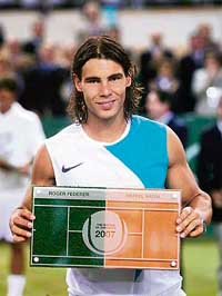 Rafael Nadal holds the trophy after beating Roger Federer in the Battle of the Surfaces tennis match played on a special court  half clay, half grass  in Mallorca, Spain, on Wednesday. Nadal won 7-5, 4-6, 7-6. 