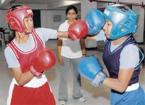 Students practice under the watchful eye of boxing coach Sangeeta Rani