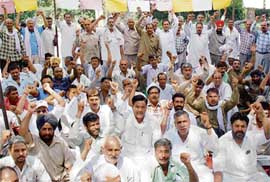 Haryana Roadways employees raise slogans during a dharna staged at Industrial Area here on Friday.
