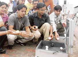 Eggs being cooked in a solar cooker on Sun Day at Panjab University in Chandigarh on Thursday.
