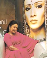 An amused Aroona Irani beside the poster of the female lead Anupama