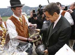 Nicolas Sarkozy (right), Frances UMP political party presidential candidate, is offered a cow bell during a campaign visit in Le Petit Bornand, French Alps, on Friday. Sarkozy faces socialist party presidential candidate Segolene Royal in the May 6 run-off vote.
