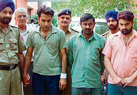Pardeep Rathore (left) and his accomplice in police custody for faking a car theft in Chandigarh.