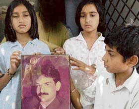 One of the daughters of the deceased (centre) shows her father Rajbirs photograph at their residence in Sector 2, Panchkula
