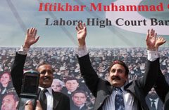 Pakistani suspended Chief Justice Iftikhar Muhammad Chaudhry (right) waves to supporters and lawyers upon arrival at the Lahore High Court on Sunday.
