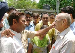 Relatives of the missing Hindu girl, who allegedly eloped with a Muslim boy, argue with BJP leader Satpal Gosain outside his residence.