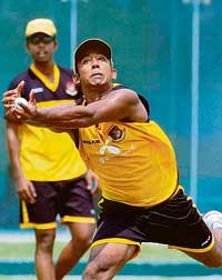 Bangladeshs Aftab Ahmed catches the ball as his team-mate Syed Russell looks on during a net practice session at the Mirpur stadium in Dhaka on Tuesday. 