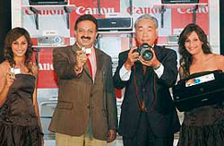 President & CEO of Canon India Kensaku Konishi (2nd from right), vice-president Alok Bharadwaj, along with models pose at the launch of digitial cameras in New Delhi.