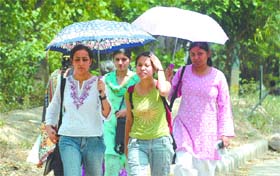 Girls holding umbrellas to save themselves from the heat in the Capital