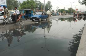 Commuters are having a tough time as sewage water overflows onto the GT Road just outside bus stand in Jalandhar on Thursday. 