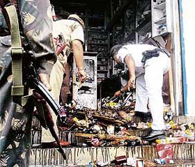 Security personnel inspect the site of a blast in Sivasagar, Assam
