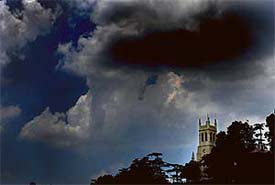 Clouds play hide and seek in Shimla on Friday. A drizzle in the state capital dipped the temperature.