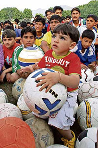 A child is all ears as Argentinian football trainer Juan Marcos Troia imparts the basics of the game to a group of boys at a special camp in Srinagar on Friday.