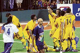 Malaysian players celebrate their victory while Indias Prabhjot Singh (centre) looks on dejectedly at the end of the second semifinal of the 16th Sultan Azlan Shah hockey tournament in Ipoh on Friday.