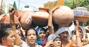 Activists of BJP Mahila Morcha shout slogans against Delhi Chief Minister Sheila Dikshit during their demonstration for better water supply in front of the Jal Board office, Jhandewalan in the Capital.