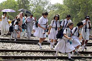 Throwing caution to the winds, schoolchildren and their parents cross railway tracks in Sonepat.