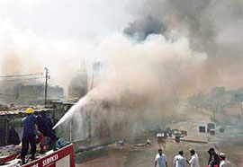 Pakistani firefighters extinguish fires after protesters set light to buildings in Karachi on Sunday. 