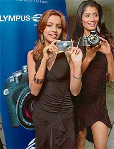 Models pose at the launch of Olympus digital cameras in New Delhi