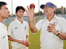 Former Haryana player Sarkar Talwar gives bowling tips to budding cricketers at the ongoing zonal cricket camp at the PCA Stadium, Mohali