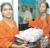 Two Greenpeace activists offer ice-creams in cups with the logo Ban the Bulb written on it to employees at the Philips Electronics office in the Capital
