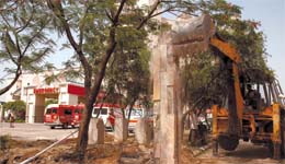 A bulldozer of the National Highway Authority demolishes an illegal wall of Apollo Hospital in the Capital 